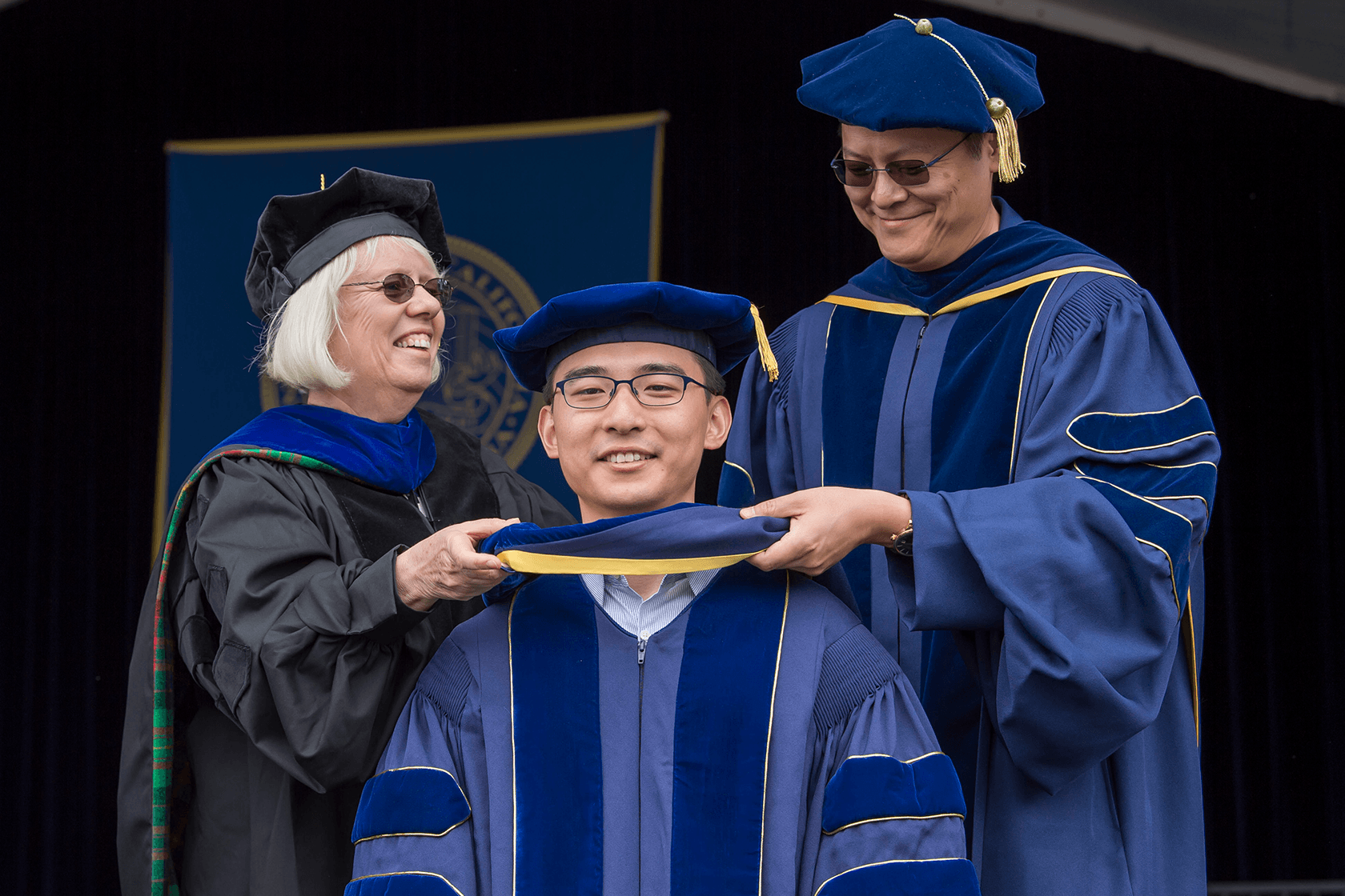 Associate Graduate Dean Mary Hegarty helping hood a student at Commencement